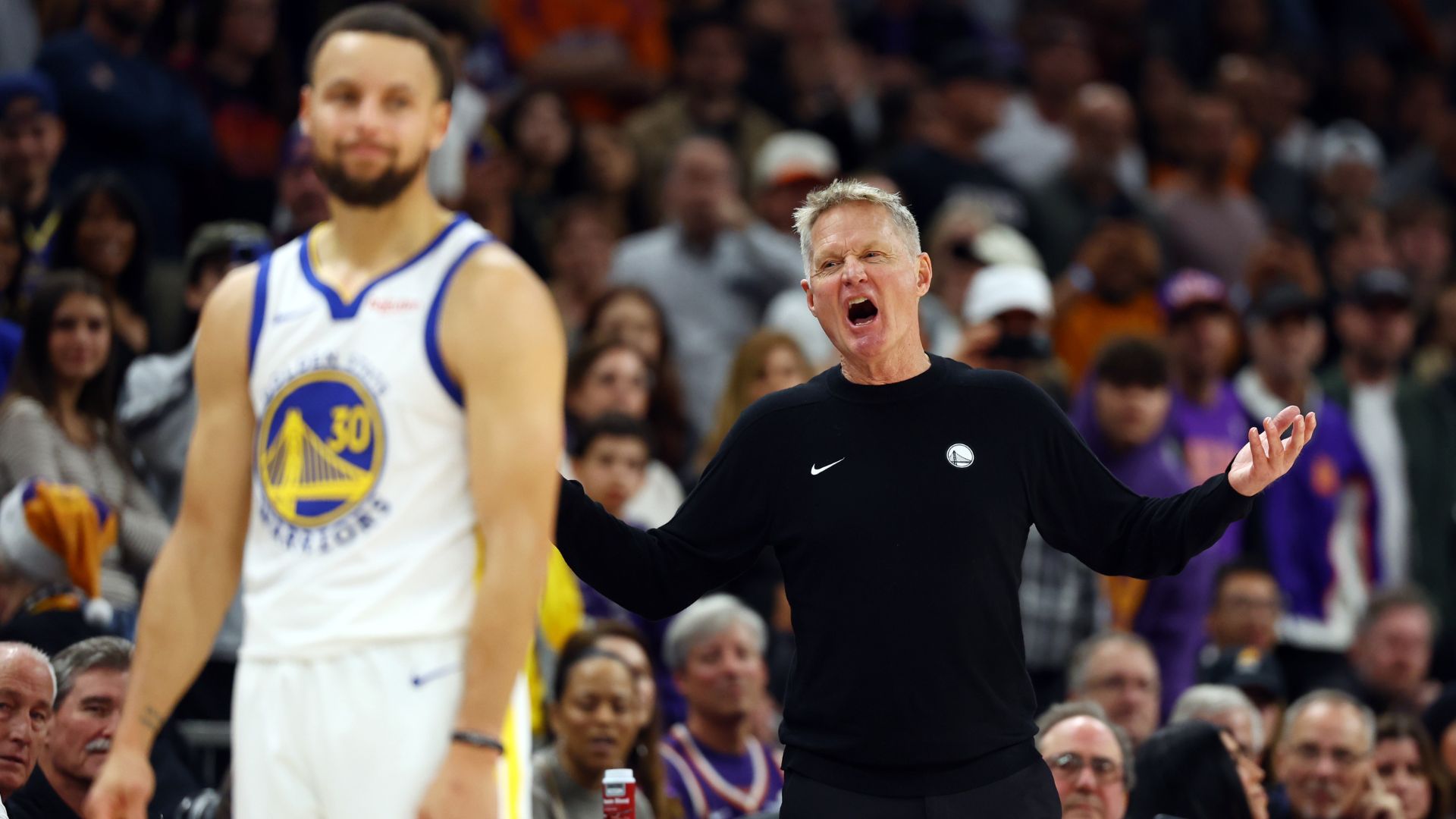 Dec 18, 2025; Phoenix, Arizona, USA; Golden State Warriors guard Stephen Curry (30) reacts alongside head coach Steve Kerr against the Phoenix Suns in the second half at Mortgage Matchup Center.