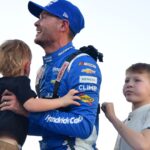 Nov 2, 2025; Avondale, Arizona, USA; NASCAR Cup Series driver Kyle Larson (5) celebrates his championship victory with son Cooper and Owen following the Cup Series Championship race at Phoenix Raceway