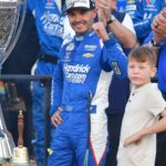 Nov 2, 2025; Avondale, Arizona, USA; NASCAR Cup Series driver Kyle Larson (5) celebrates his championship victory following the Cup Series Championship race with son Owen at Phoenix Raceway.