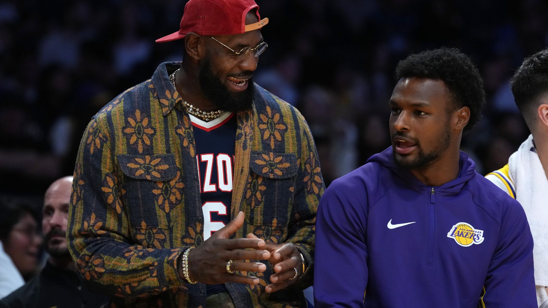 Oct 24, 2025; Los Angeles, California, USA; Los Angeles Lakers forward LeBron James (left) and son Bronny James watch from the bench in the second half against the Minnesota Timberwolves at Crypto.com Arena