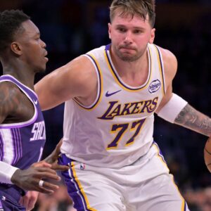Dec 28, 2025; Los Angeles, California, USA; Sacramento Kings guard Dennis Schroder (17) defemds Los Angeles Lakers guard Luka Doncic (77) in the second half at Crypto.com Arena.