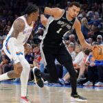Dec 25, 2025; Oklahoma City, Oklahoma, USA; San Antonio Spurs forward Victor Wembanyama (1) drives down the court beside Oklahoma City Thunder guard Jalen Williams (8) during the second quarter at Paycom Center