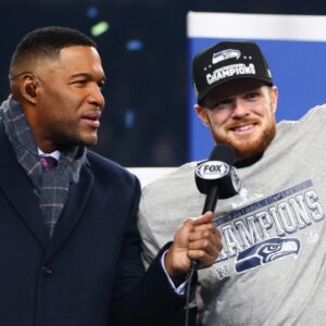 Seattle Seahawks quarterback Sam Darnold (14) celebrates on the podium after defeating the Los Angeles Rams in the 2026 NFC Championship Game at Lumen Field.