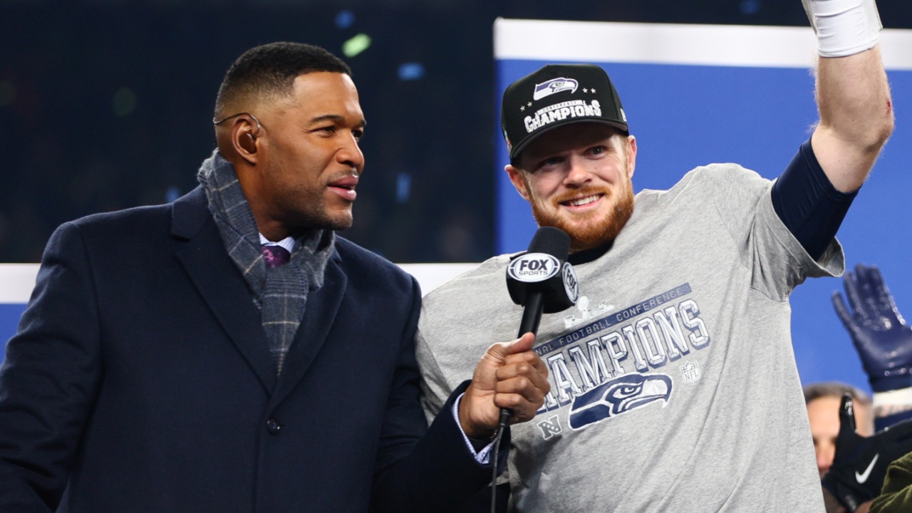 Seattle Seahawks quarterback Sam Darnold (14) celebrates on the podium after defeating the Los Angeles Rams in the 2026 NFC Championship Game at Lumen Field.