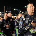 Kyle Busch stands for the national anthem before the NASCAR Cup Series Duel during Speedweek, Thursday, Feb. 12, 2026.