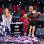Feb 15, 2026; Daytona Beach, Florida, USA; NASCAR Cup Series driver Tyler Reddick (45) celebrates with son Beau Reddick as wife Alexa DeLeon holds son Rookie Reddick in victory lane after winning the 68th running of the Daytona 500 at Daytona International Speedway