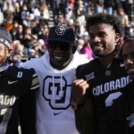 Colorado Buffaloes safety Shilo Sanders (21) and head coach Deion Sanders and quarterback Shedeur Sanders (2) and social media producer Deion Sanders Jr. following the win against the Oklahoma State Cowboys at Folsom Field.