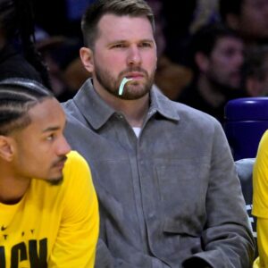 Feb 12, 2026; Los Angeles, California, USA; Los Angeles Lakers guard Luka Doncic (77) looks on from the bench as he chews on a dental flosser in the second half against the Dallas Mavericks at Crypto.com Arena.