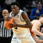 BYU Cougars forward AJ Dybantsa (3) keeps the ball from Texas Longhorns forward Camden Heide (5) in the second half during a first round game of the men's 2026 NCAA Tournament at Moda Center.