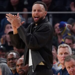 Golden State Warriors guard Stephen Curry (30) cheers from the bench during a game against the Denver Nuggets in the third quarter at Chase Center.