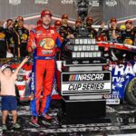 Aug 31, 2025; Darlington, South Carolina, USA; NASCAR Cup Series driver Chase Briscoe (19) celebrates his win with his son Brooks at the Cookouts Southern 500 at Darlington Raceway.