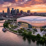 Aerial view of Nashville's new enclosed NFL stadium on Cumberland River at sunset with city skyline