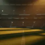 Empty floodlit stadium pitch at golden hour with dramatic shadows, packed stands in background, warm and cool colour contrast.