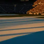 Floodlit stadium with national colours reflected on pitch, packed stands, golden-hour lighting, dramatic shadows.