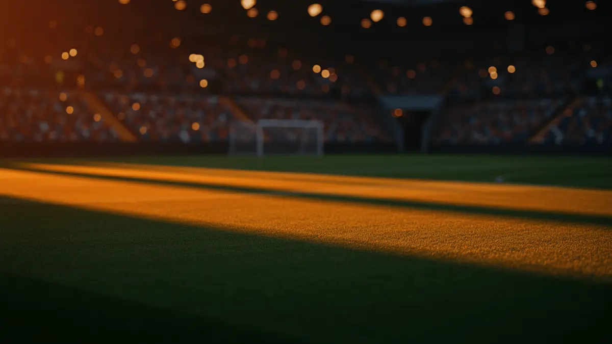 Floodlit stadium pitch with orange and blue-yellow atmospheric lighting, dramatic shadows, and golden-hour mood.