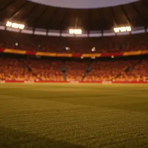 Floodlit stadium pitch at golden hour with red-gold-white atmospheric lighting, packed stands blurred in background, cinematic sports photography aesthetic.