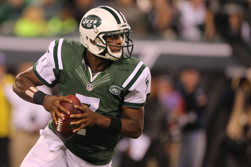Geno Smith in a New York Jets uniform, preparing to throw a football.