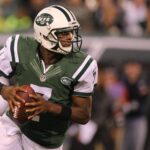 Geno Smith in a New York Jets uniform, preparing to throw a football.