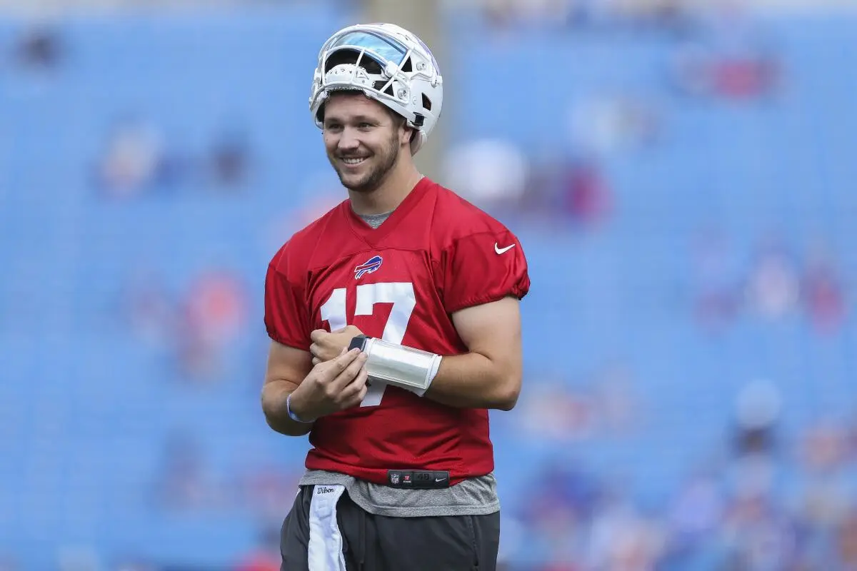 Josh Allen in a red practice jersey with Buffalo Bills logo during warmups.