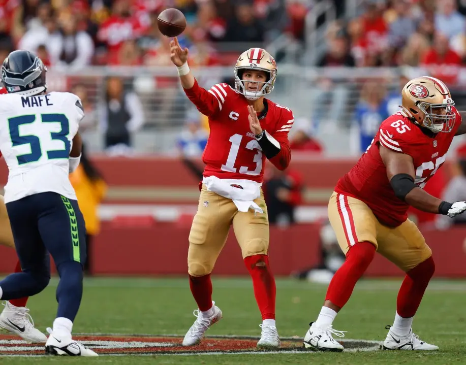 Brock Purdy of the San Francisco 49ers throwing a football during a game against the Seattle Seahawks