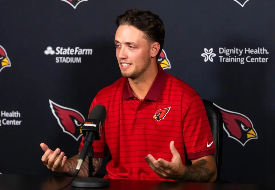 Carson Beck wearing an Arizona Cardinals polo shirt speaking at a press conference