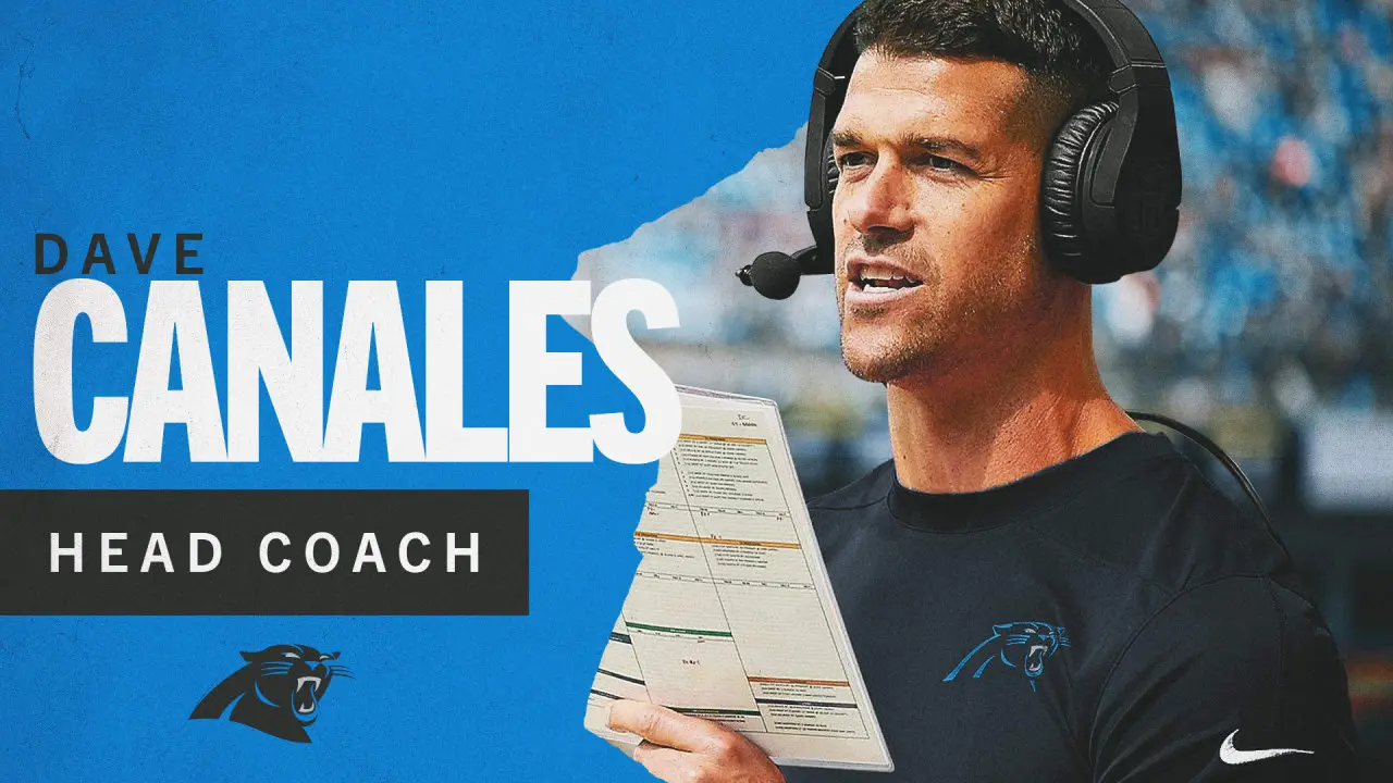 Carolina Panthers head coach Dave Canales wearing a headset and holding a play sheet.