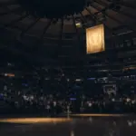 Championship banner rising above the court at Madison Square Garden during an NBA opening-night ceremony