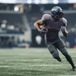 Quarterback escapes the pocket and runs with the football in a stadium