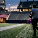 Quarterback silhouette holding a football during a late NFL trade and roster transition